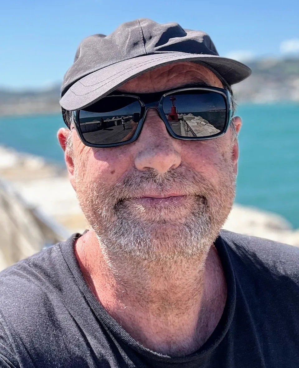 Klaus Wanek mit Kappe und Sonnenbrille am Meer